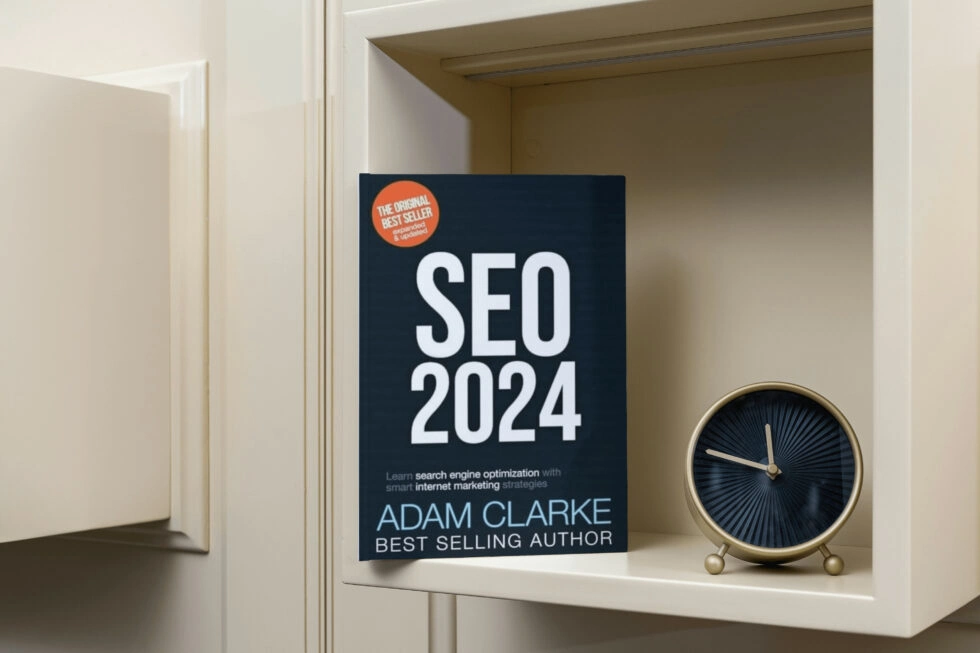 A book titled 'seo 2024' by adam clarke, a best-selling author, along with a retro-style analog clock on a shelf.